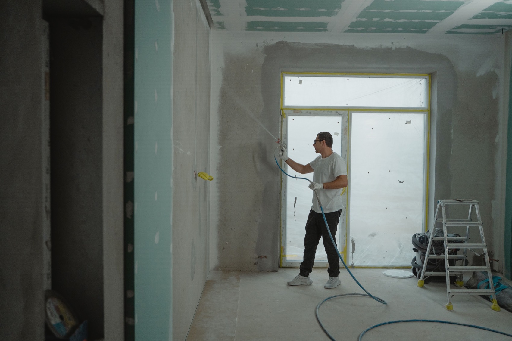Application de peinture au pistolet airless lors d'une rénovation intérieure par Neo Construction 24