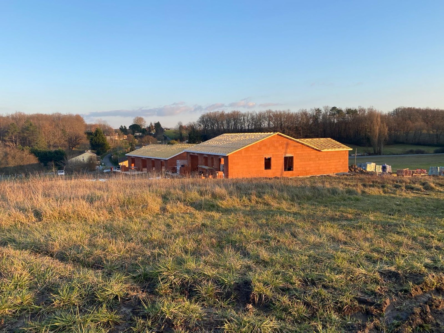 Maison en briques réalisée par Neo Construction 24, gros œuvre au coucher du soleil