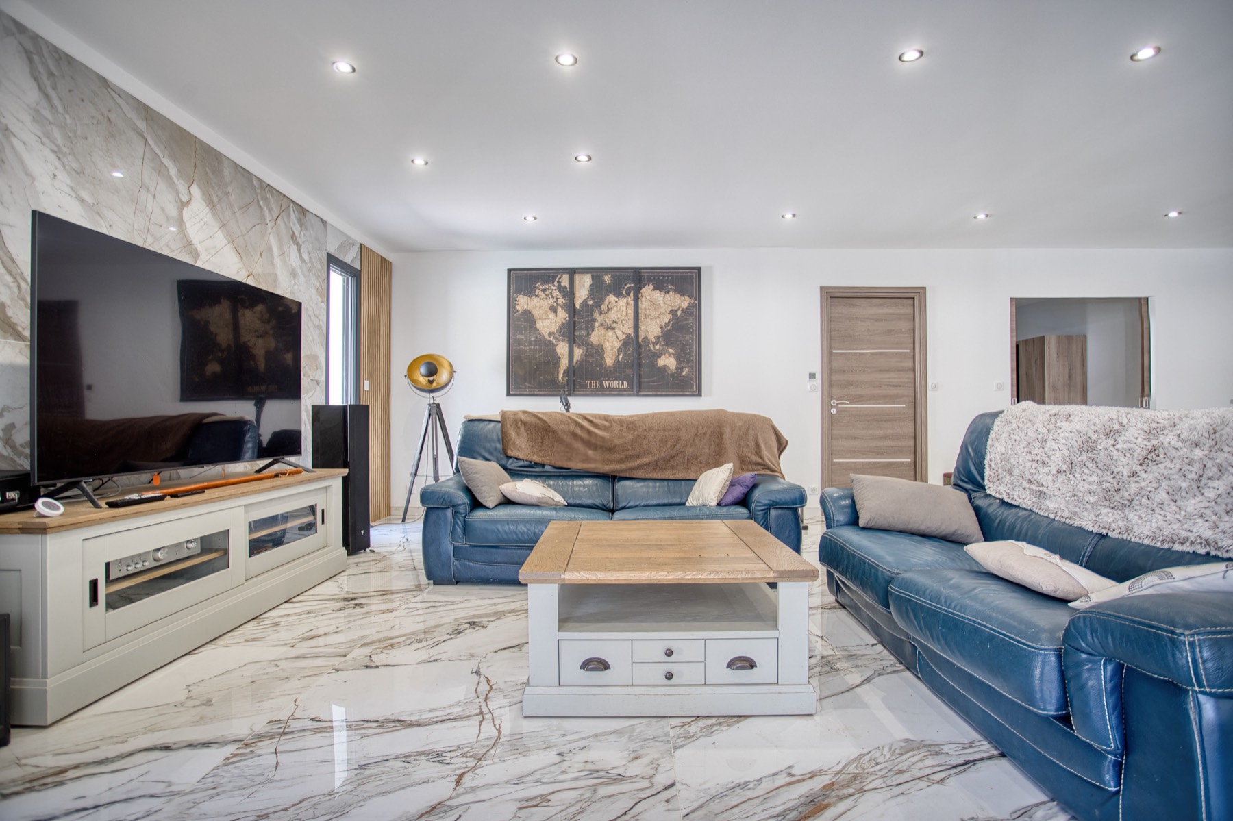 Salon avec sol et mur en marbre, faux plafond et spots, par Neo Construction 24